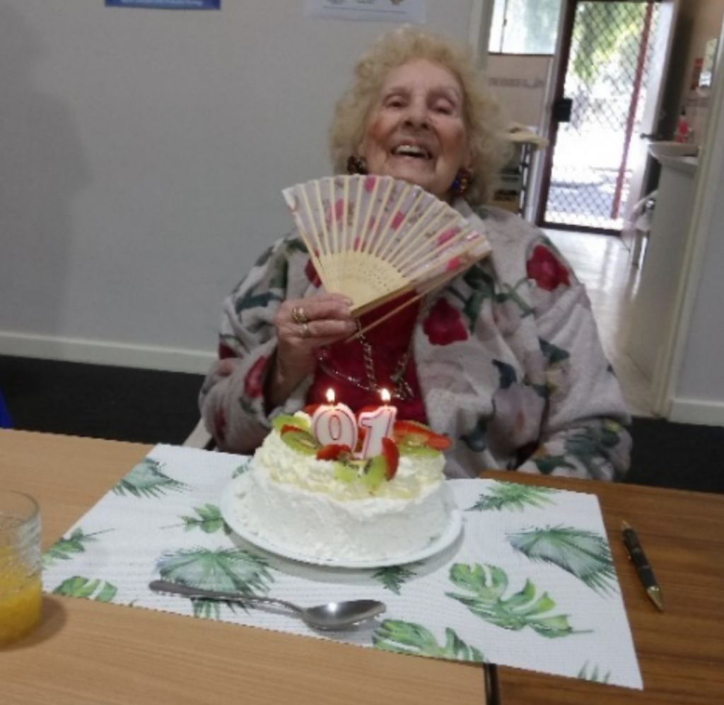 elderly woman celebrating birthday with a cake